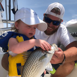 A fisherman holding a wiper (hybrid striped bass) caught in GA.