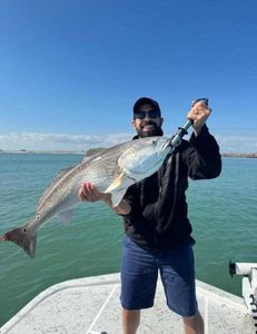 Angler holding a large redfish caught while fishing in Port Isabel