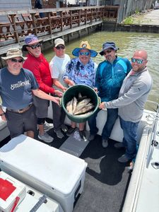 Fishing group displaying their catch in green bucket on boat in Port Clinton OH