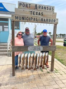 Successful fishing trip displaying speckled trout and redfish catch at Port Aransas Texas Municipal Harbor