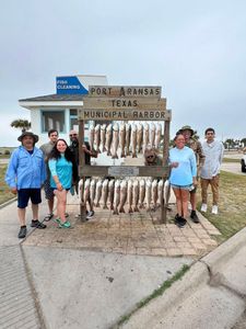 Group of anglers displaying their redfish catch at Port Aransas Texas Municipal Harbor fish cleaning station
