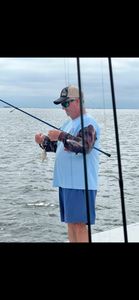 Fishing from boat deck in Rockport TX waters with rod and reel