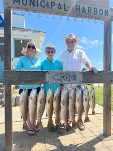 Fishing charter displaying multiple redfish and speckled trout catch at Rockport TX municipal harbor