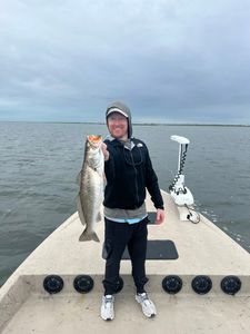 Angler holding large speckled trout on fishing boat in Rockport TX waters