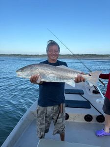 Angler holding large redfish on fishing boat in Rockport TX waters