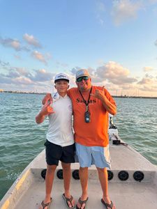 Two people posing together on fishing boat deck in Rockport TX waters