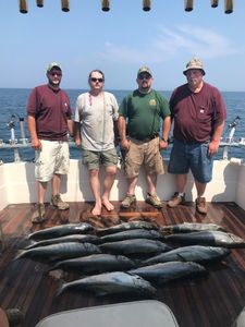 4 people fishing in NY with 2 big fish