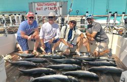Four people fishing on the shore in NY
