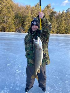 A fisherman holding a 27-inch catch in NY
