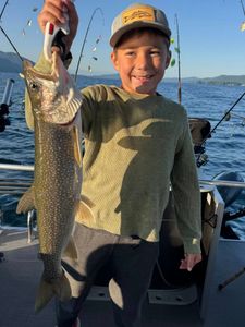 A fisherman catches a lake trout in Lake George