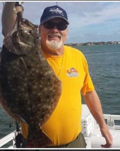 An angler with a large summer flounder fish caught at Jensen Beach