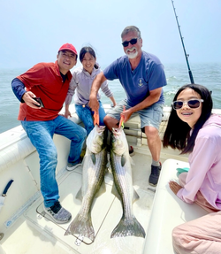 Successful striped bass fishing trip on boat with two large striped bass caught in Port Monmouth Road NJ waters