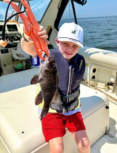 A fisherman with a sea bass catch on Port Monmouth Road