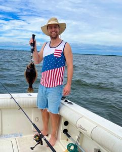 A single fisherman holds up a 13-inch catch on Port Monmouth Road