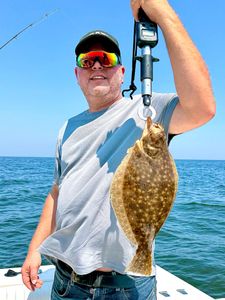 A fisherman catches a summer flounder on Port Monmouth Road