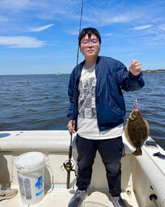 A person holds a summer flounder fish measuring 11 inches at Port Monmouth Road.