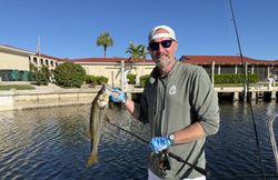 Angler holding caught snook while fishing in Punta Gorda FL waters