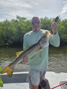 Angler holding large snook catch on fishing boat in Punta Gorda FL