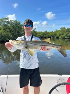 Snook catch displayed on fishing boat in Punta Gorda FL waters with mangroves in background