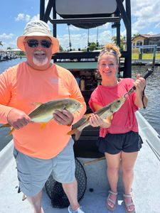 Two anglers displaying caught snook and crevalle jack fish on fishing boat in Punta Gorda FL