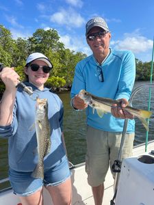 Two anglers display freshly caught snook and speckled trout on fishing boat in Punta Gorda FL
