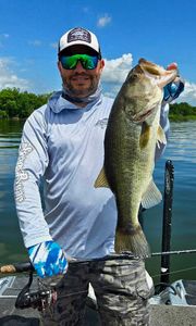 Angler holding a large largemouth bass caught while fishing in Quitman