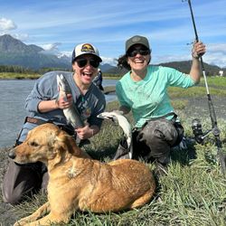Two people fishing on the shore in Alaska