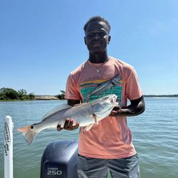 A fisherman holding a redfish in SC