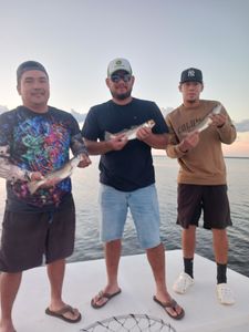 Two people fishing with rods in Manteo, North Carolina