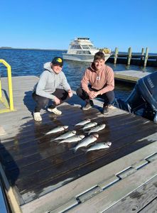 A pair of anglers celebrating a successful fishing trip in Manteo