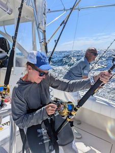 Two people on a boat in New Jersey enjoying cruises and fishing activities.