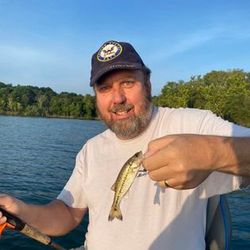 Angler holding a 6-inch fish in Branson