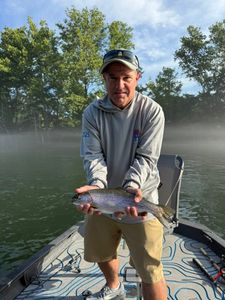 Angler catches a rainbow trout fishing in Branson