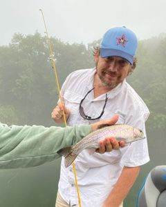 Angler with a rainbow trout in Branson