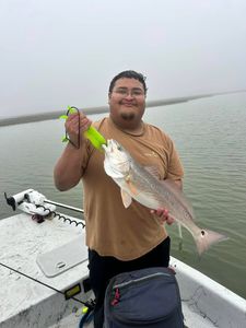 A fisherman catches a vibrant redfish in Rockport