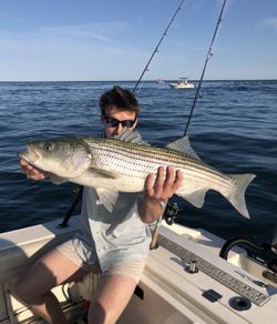 Two people fishing for striped bass in MA