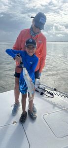 A person holding a spotted weakfish, 14 inches long, in Corpus Christi