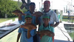 Three fishing rods and a group of four people in Islamorada