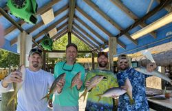 Four anglers displaying fresh caught yellowfin fish at cleaning station in Islamorada FL