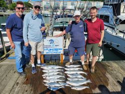 Successful fishing charter displaying catch of Coho Salmon and other fish species on dock in Port Washington WI