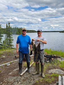 Two anglers displaying their fresh catch of multiple fish species at a lakeside fishing spot in Port Washington WI