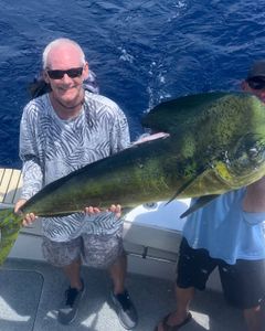 Large mahi mahi caught while fishing in Islamorada FL displayed on boat deck over ocean water
