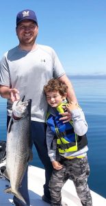 Two anglers fishing for a lake trout in Traverse City