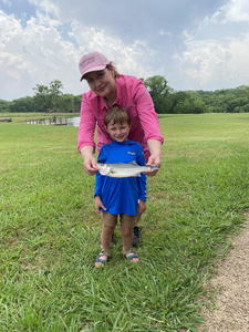 Big striped bass reeled in on a partly cloudy day with strong storms possible