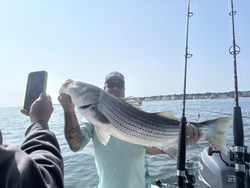 Striped Bass on the line at The Waterfront Club - clear skies and epic fishing!