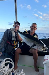 Two anglers holding a large yellowfin tuna on fishing boat in New Port Richey FL