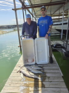 Two people fishing in Pottsboro with a 22-inch fish