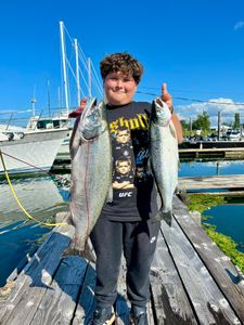 Two coho salmon caught by three people fishing in Portland