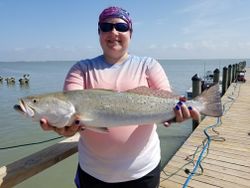 Angler holding a spotted weakfish catch in Aransas Pass