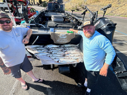 Two people standing in Colusa, fishing with rods